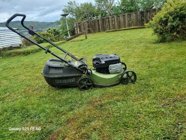 Masport mower on a freshly cut back lawn with Wellington hills behind